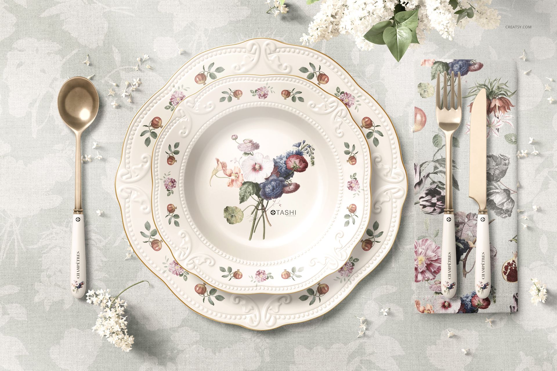 Elegant PSD mockup showing a decorative plate, floral napkin, and utensils arranged on a pale patterned surface.