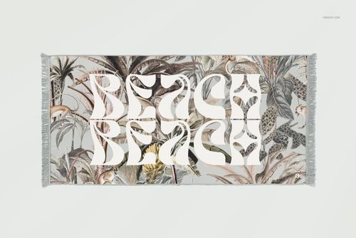 Top view of a fringed beach towel mockup featuring bold white lettering and a detailed jungle-themed design.