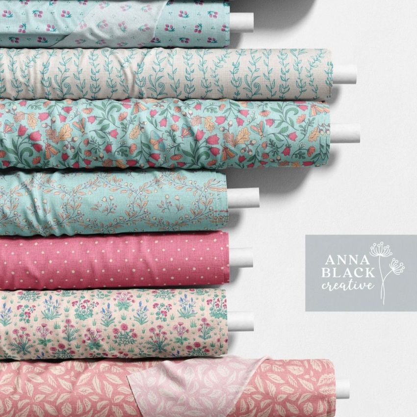 Fabric rolls mockup showing seven rolls with floral and geometric patterns in pastel pink, blue, and cream tones on a light background.