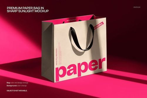 Paper bag PSD mockup featuring a beige bag with black straps and large pink lettering, set against a bright pink background.