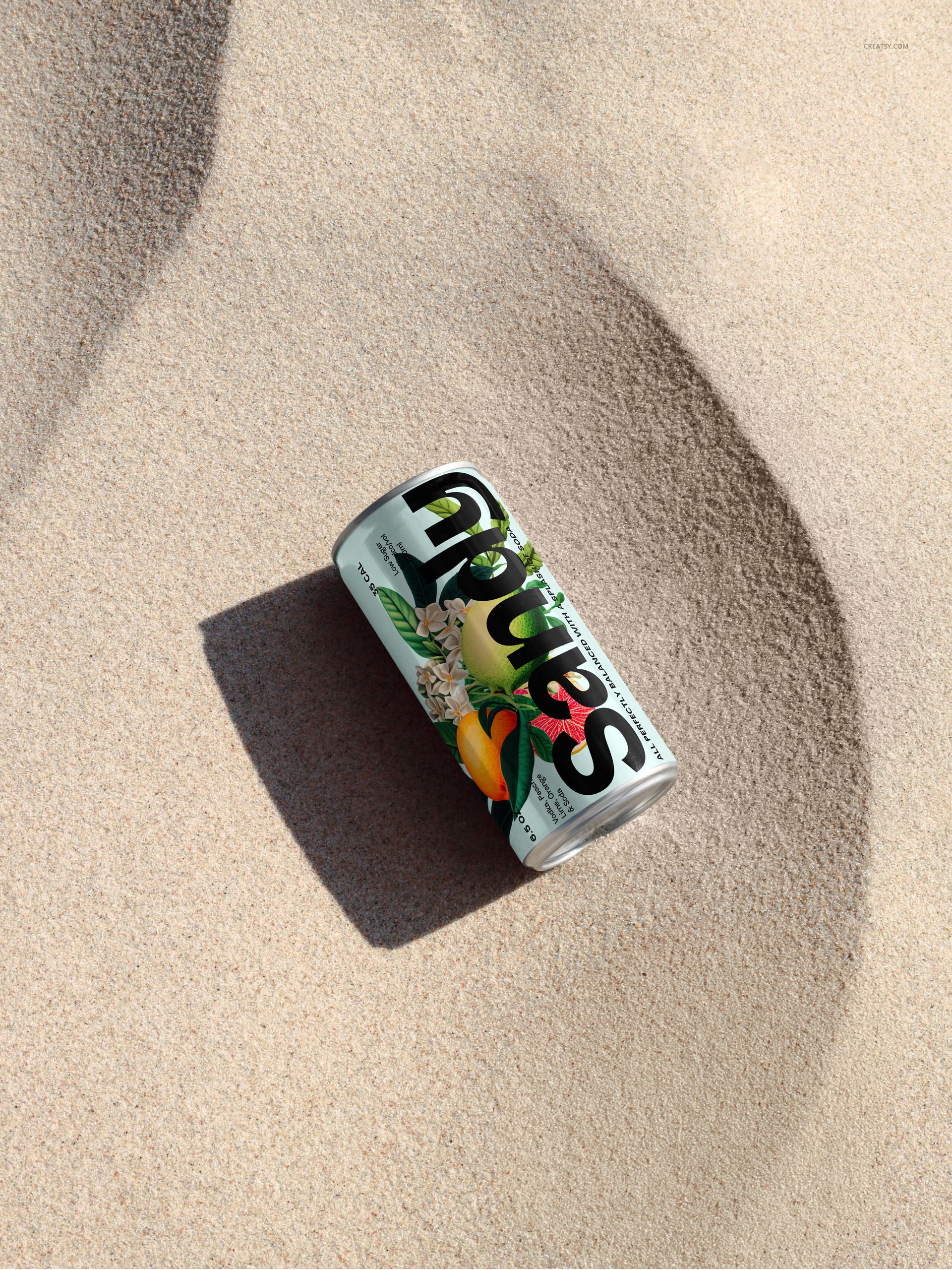 200ml can with colorful label lying on light sandy beach, viewed from above with natural sunlight and shadows.