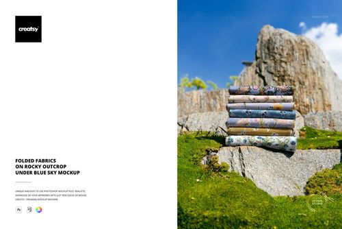 PSD mockup showing several patterned fabrics neatly stacked on rugged rocks beneath a vibrant blue sky.