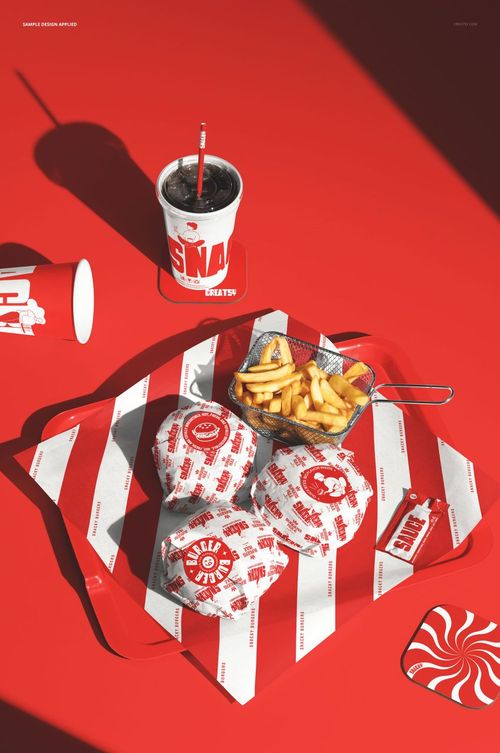 PSD mockup featuring wrapped burgers, fries, and branded drink cups on a red striped tray, viewed from above.
