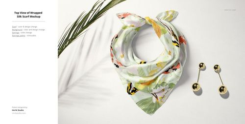 Silk scarf mockup shown from above, featuring pastel floral design, gold ball earrings, and a green palm leaf.