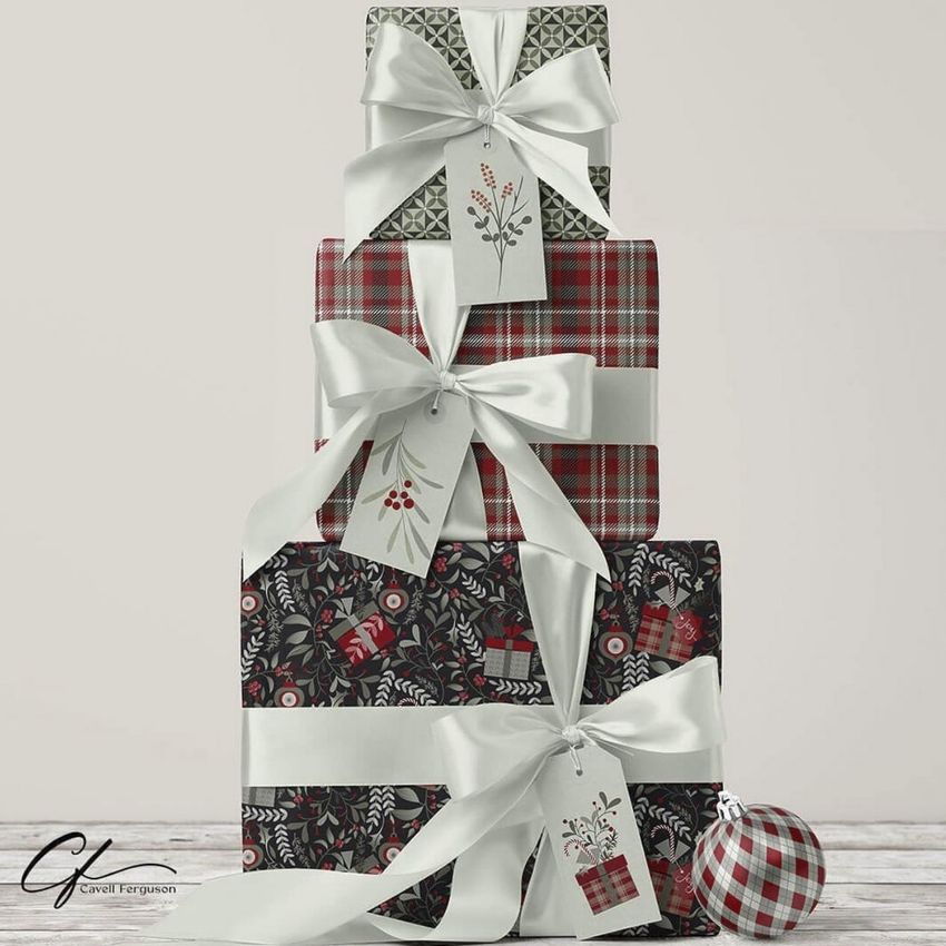 Stack of three Christmas presents mockup with festive patterned wrapping paper, white ribbons, and decorative gift tags.