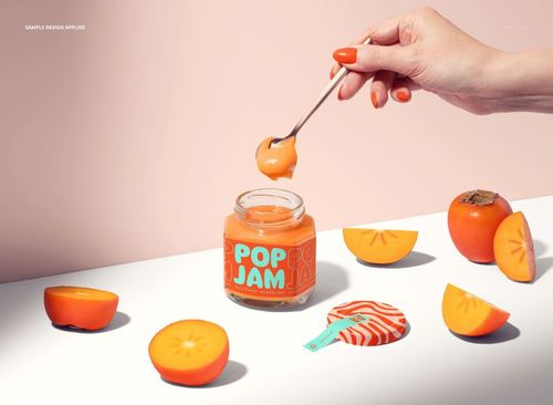 PSD mockup featuring a hexagonal persimmon jam jar, a spoon with jam, and orange fruit slices on a white surface.