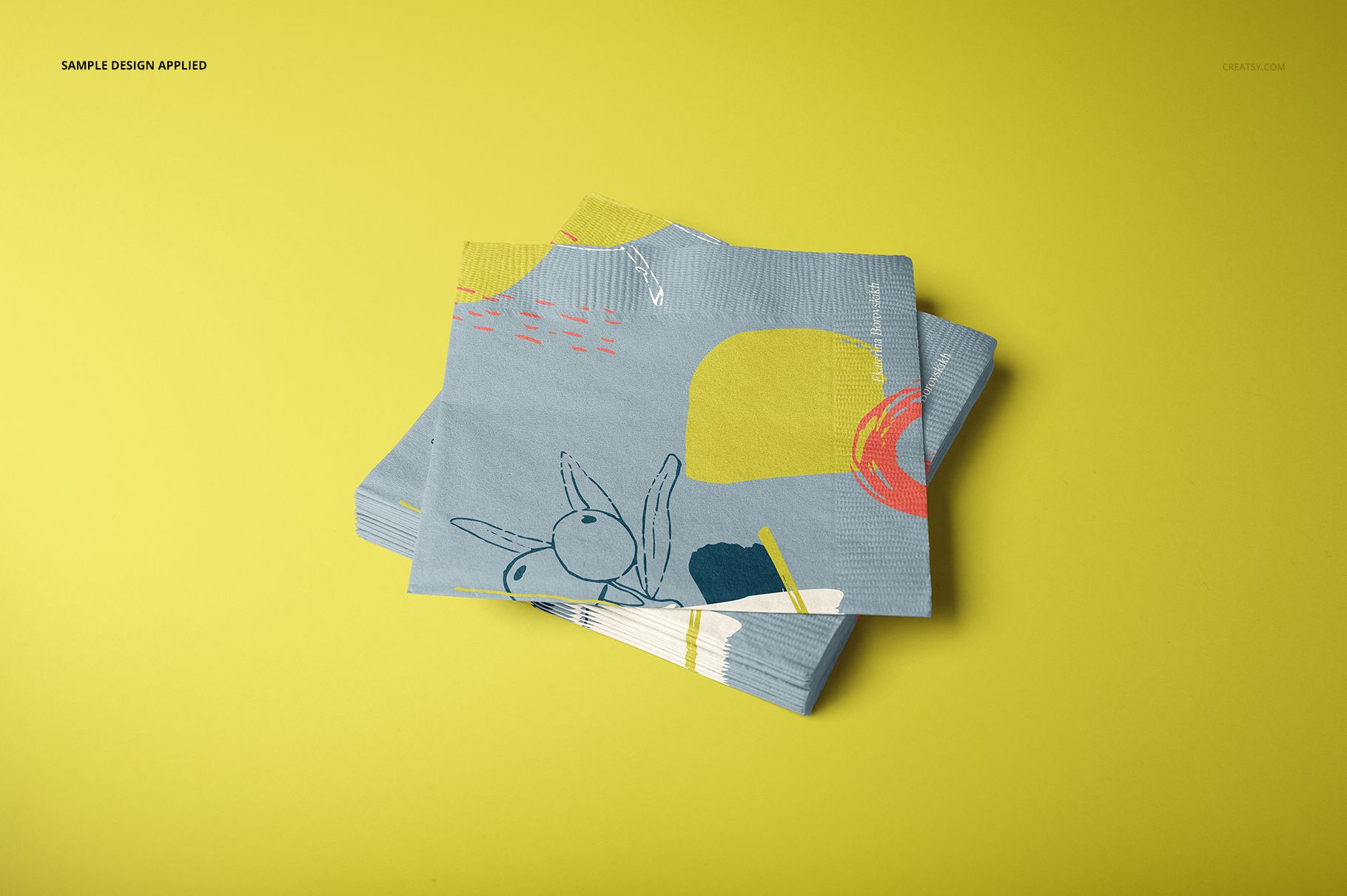 Paper napkins mockup featuring a pile of napkins with colorful abstract patterns, displayed on a solid yellow background.