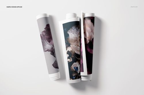 Rolled canvas print PSD mockup set showing three tubes with dark and light floral artwork, flat lay perspective.