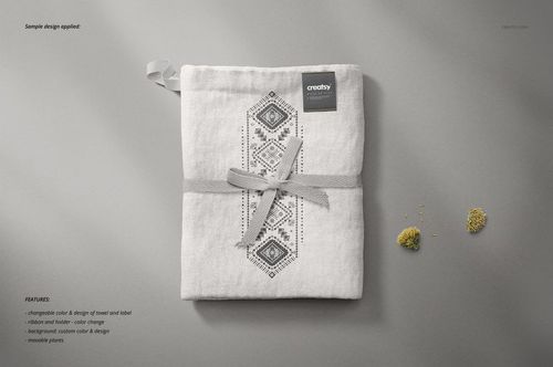 Top view of a kitchen towel mockup featuring a gray and white design, ribbon tie, and decorative pattern.