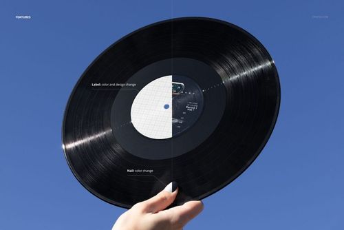 Hand holding a black vinyl record against a clear blue sky, with label and matte color change features visible on the mockup.