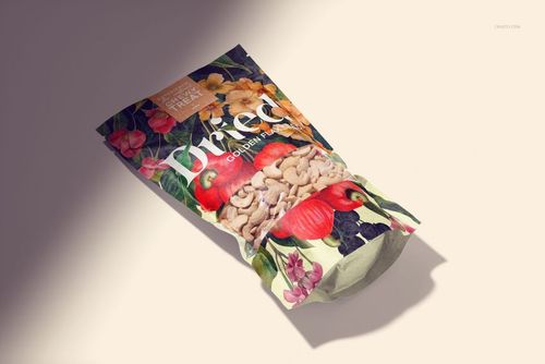Front view of a paper pouch packaging mockup with cashews, featuring colorful floral and nut illustrations.