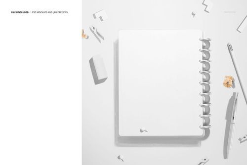Top-down perspective of a spiral planner mockup, featuring a blank white cover and surrounded by small office supplies.