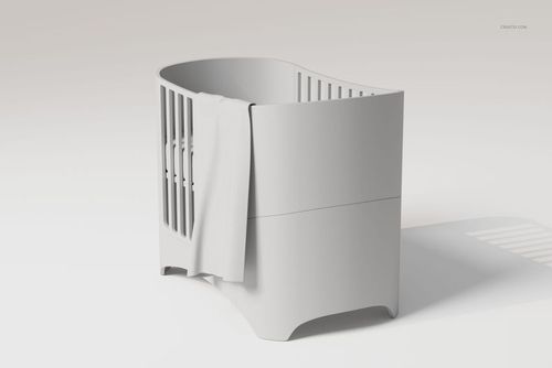 Modern crib with rounded edges in light gray, featuring a large baby blanket draped over one side, front angle view.