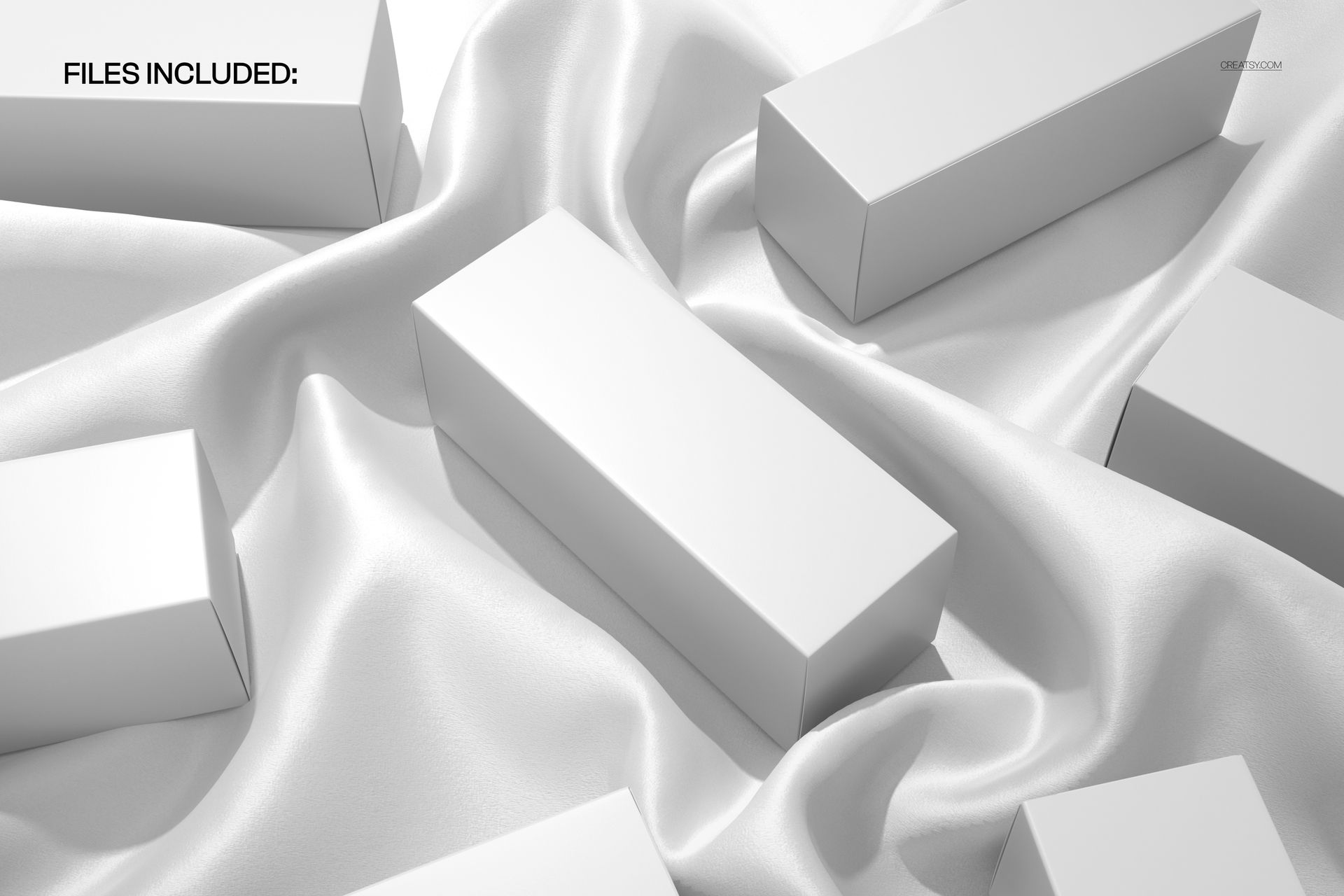 Rectangular packaging boxes arranged on a smooth, draped white silk fabric, viewed from above in a mockup scene.