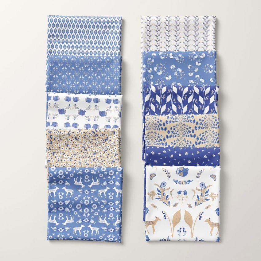 Folded fabrics mockup showing ten pieces of fabric arranged in two vertical columns, each with blue and beige folk-inspired patterns.