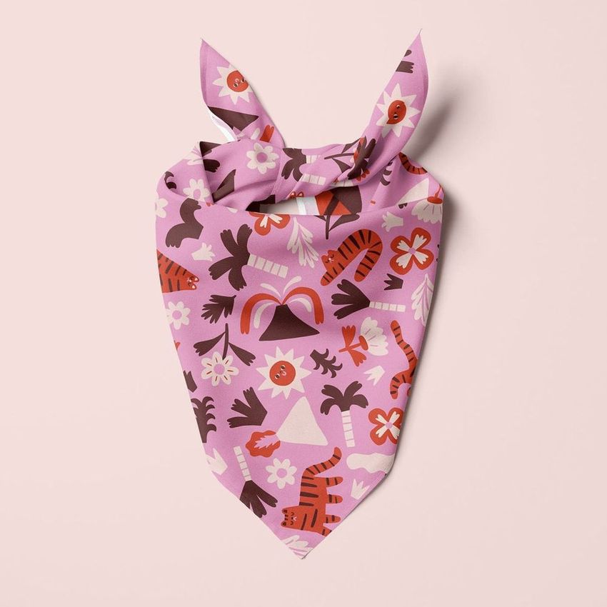 Pet bandana mockup featuring a pink fabric with playful animal and floral patterns, displayed flat on a light background.