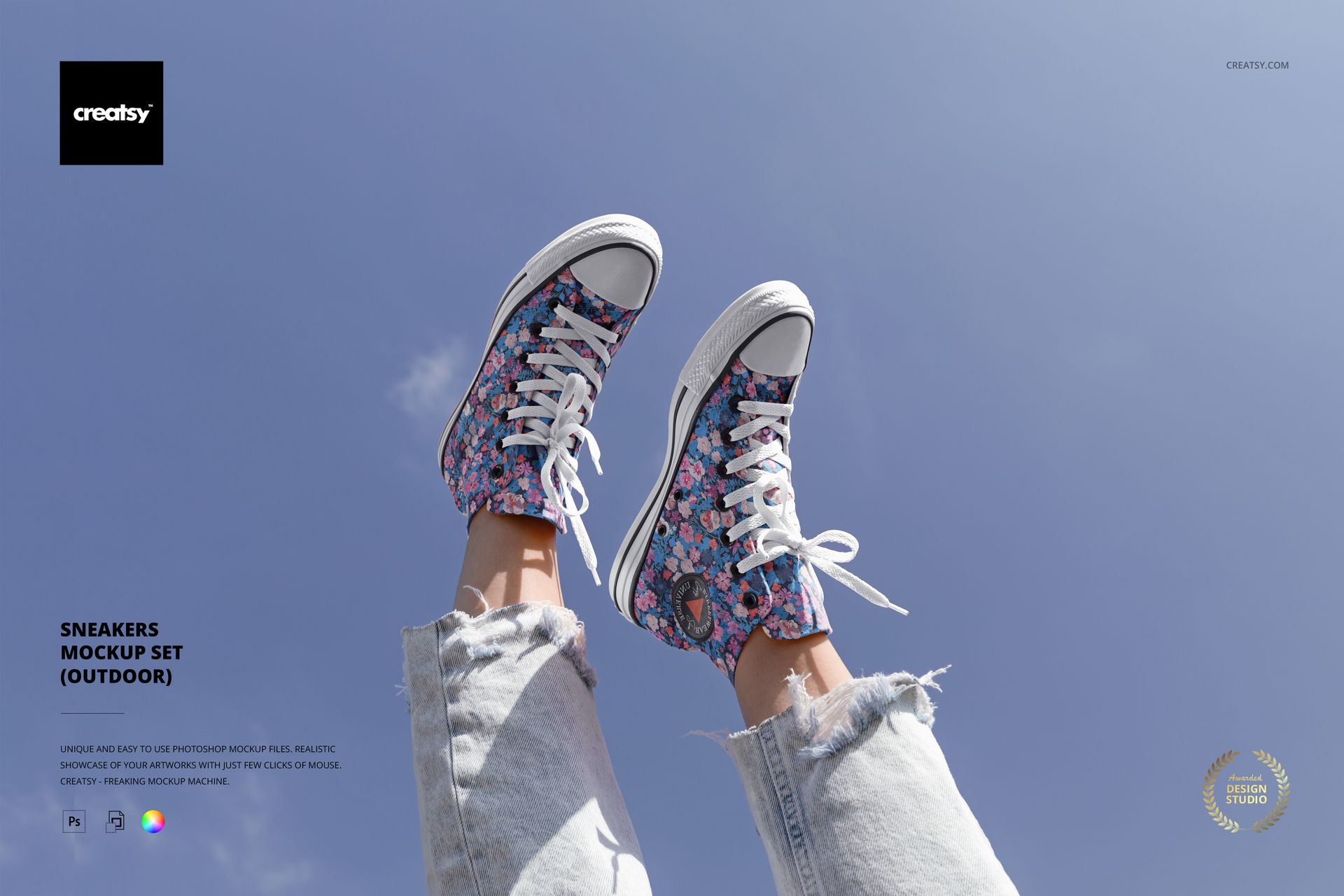 PSD mockup of floral print sneakers worn with light denim jeans, legs raised toward a bright blue sky in daylight.