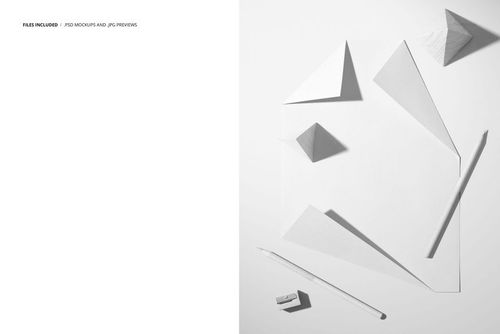 Stationery mockup featuring a blank poster with folded corners, white crayons, and geometric paper props on a light surface.