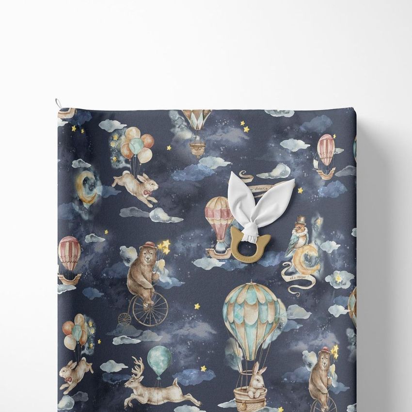 Changing pad mockup featuring a whimsical kids' pattern with animals, hot air balloons, and stars on a dark blue background.