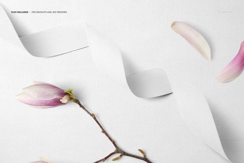 Cotton ribbon mockup displayed on pale cotton fabric, accented by magnolia blossom and scattered pink petals.