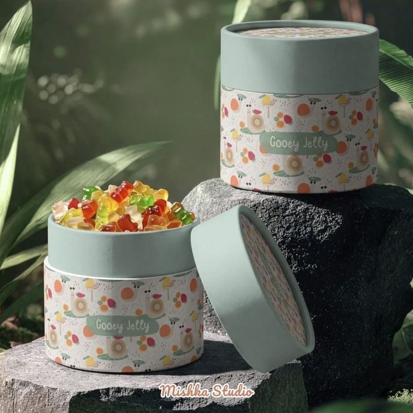 Paper tube packaging mockup featuring pastel-colored containers filled with gummy candies, set in a lush jungle environment.