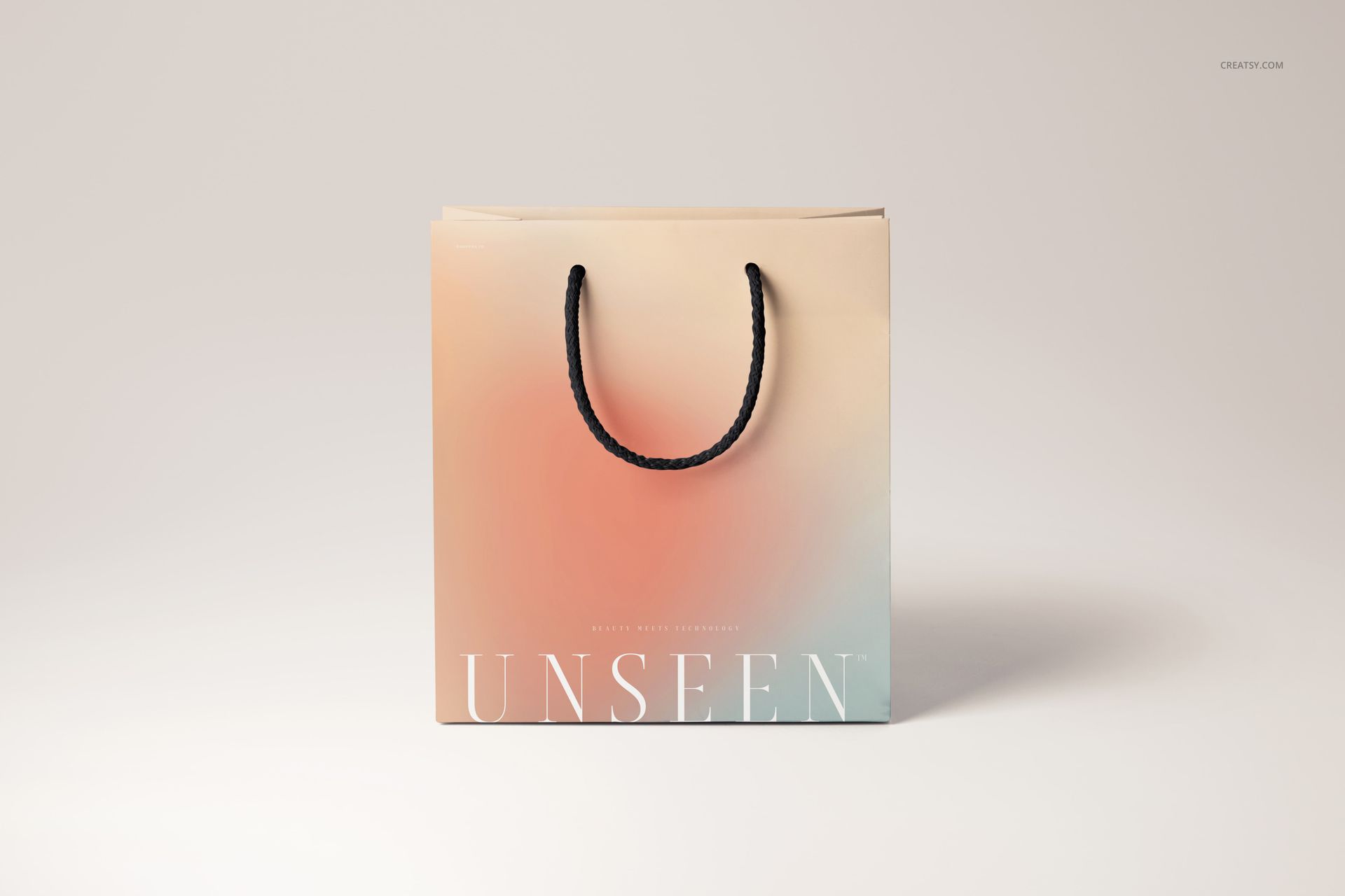 Gradient-colored gift bag mockup with black rope handles, tissue paper visible at the top, on a light background.