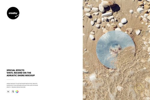 Top view of a translucent vinyl record placed on a sandy beach with small rocks and shells, PSD mockup scene.