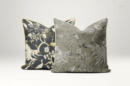 PSD mockup showing a pair of piped cushions with elegant nature-inspired motifs, one cushion in charcoal and one in taupe.