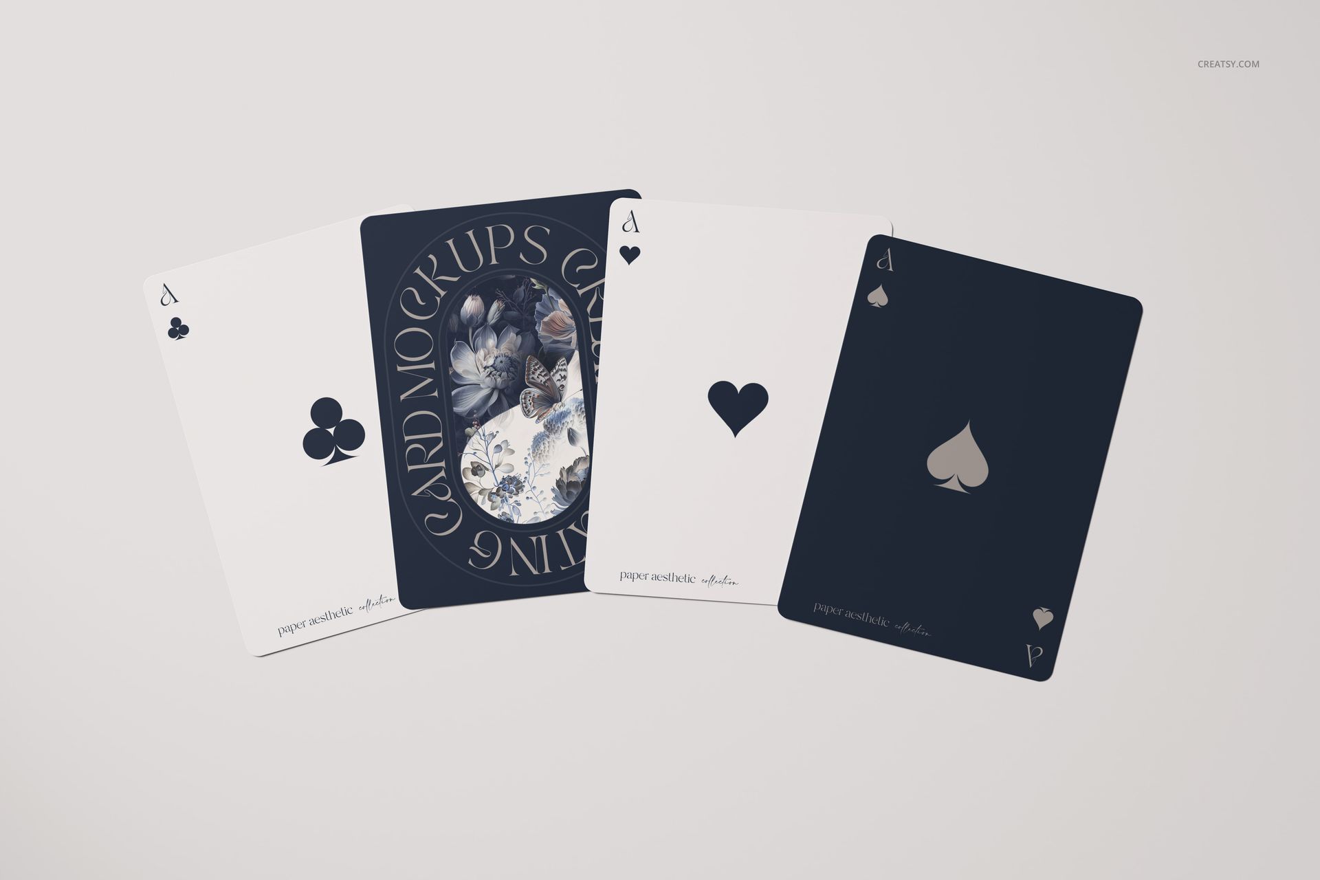 Mockup of playing cards with two dark and two light designs, including one card with a decorative illustration.