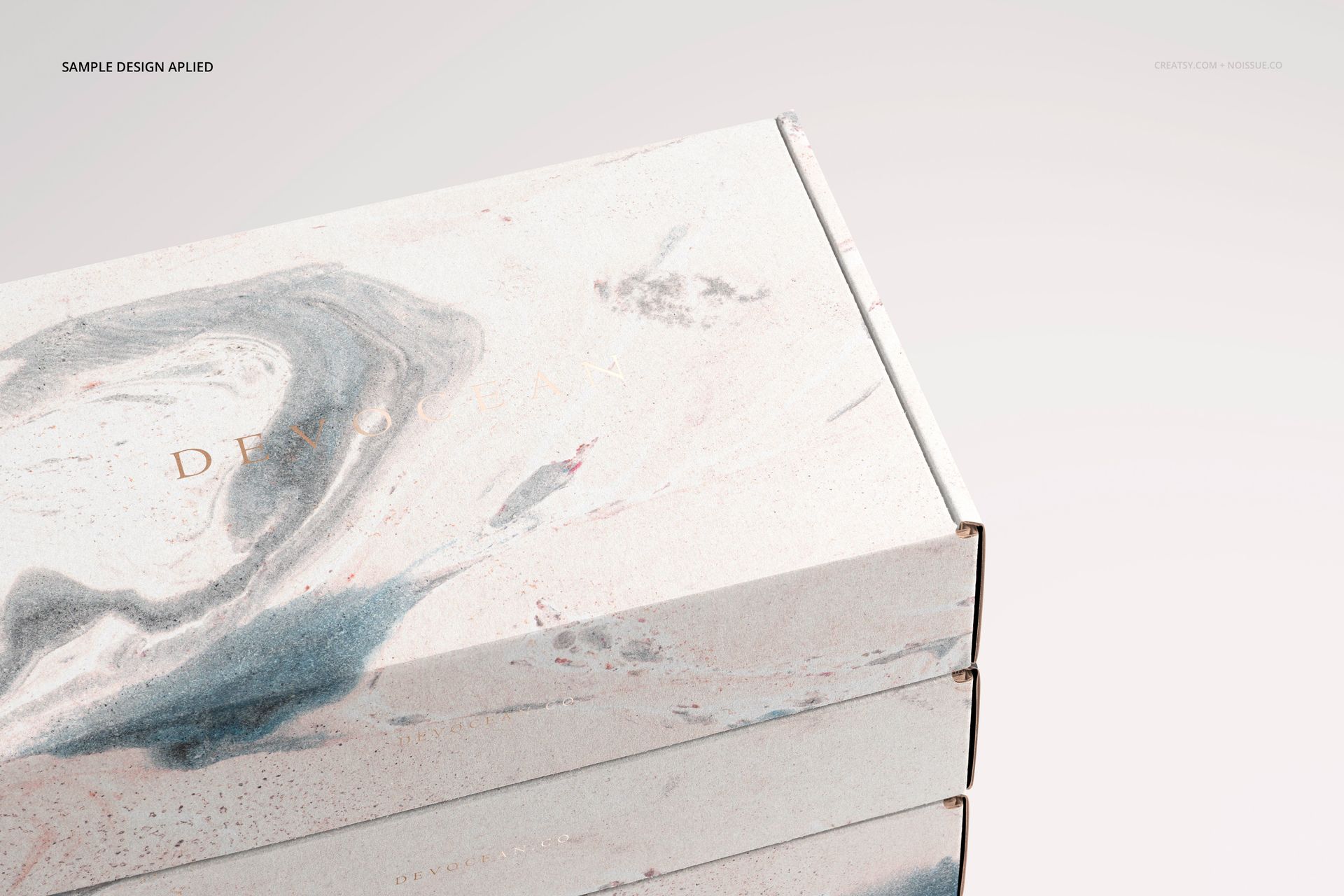 PSD mockup featuring stacked packaging boxes with light gray and blush abstract swirls, viewed from the top right corner.