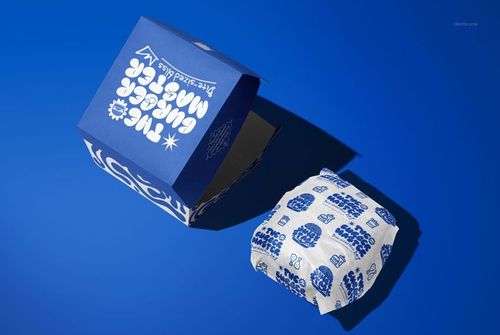 Blue burger packaging mockup with white graphic text, showing both an open box and wrapped burger on blue surface.