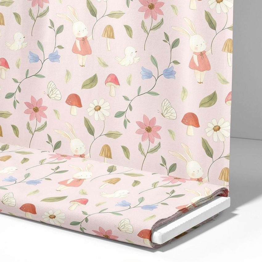 Fabric bolt mockup featuring a pastel pink material with whimsical bunny, flower, mushroom, and butterfly illustrations.