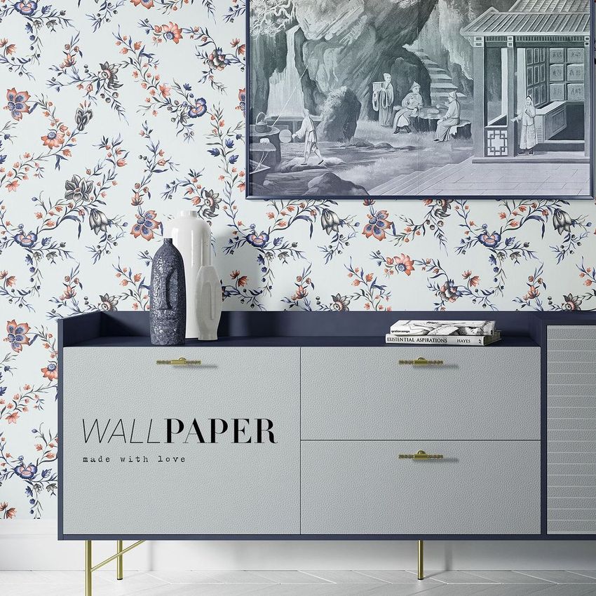 Interior wallpaper mockup showing a floral chintz pattern on a wall behind a modern cabinet with decorative vases and books.