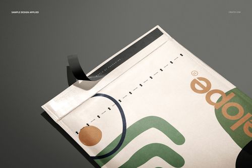 Close-up of kraft bubble mailer mockup featuring colorful geometric graphics and black tape on a gray surface.