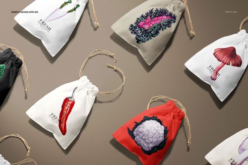 Linen drawstring pouches in various colors and botanical designs arranged on a neutral surface, top view.