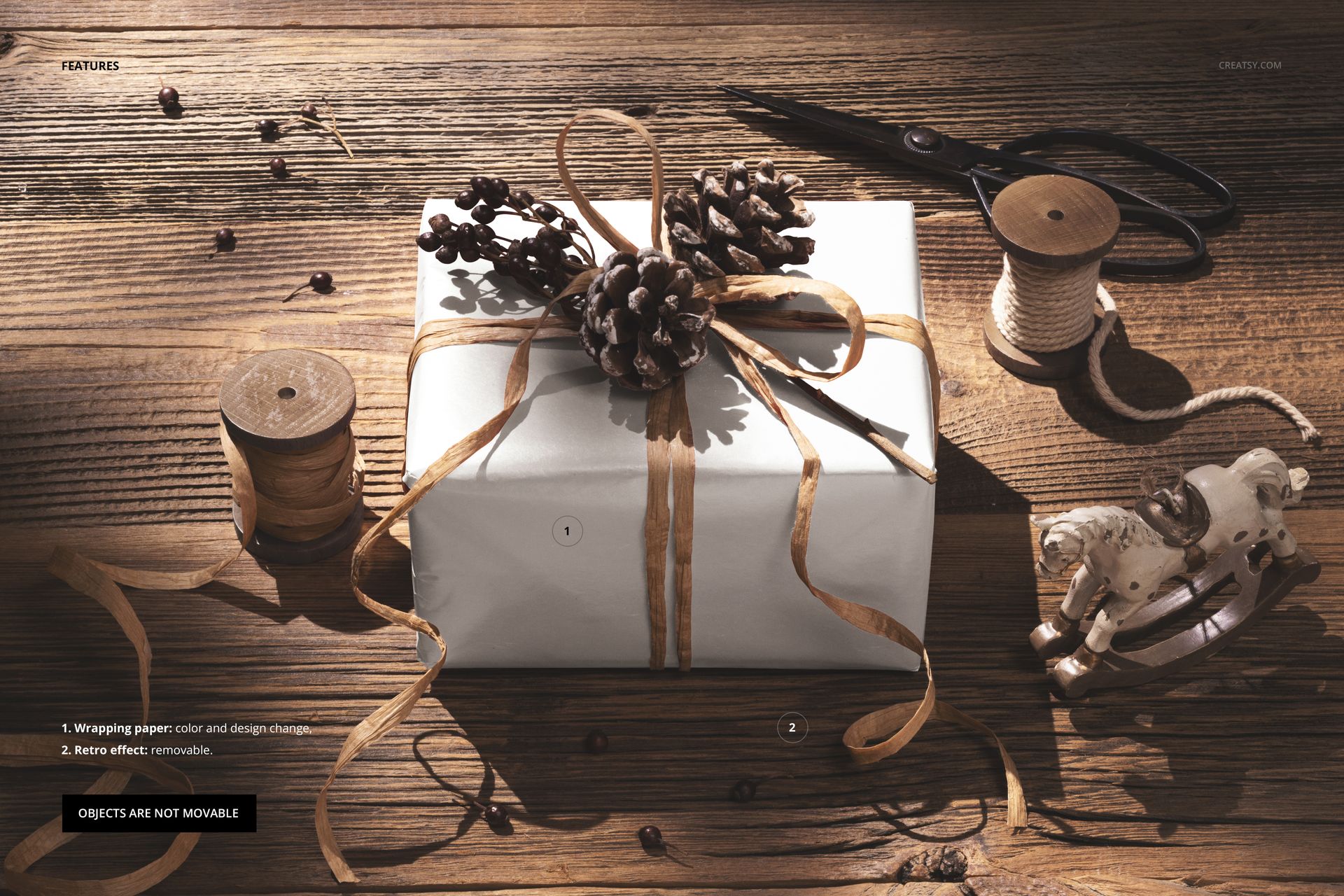 Christmas PSD mockup showing a landscape gift box with natural ribbon, pinecones, and festive tools arranged on a textured wooden table.