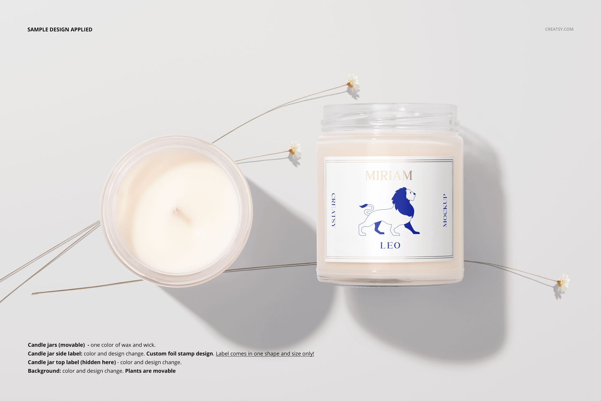 Mockup of scented soy candles in transparent jars, one with a blue and white label, surrounded by small white flowers on a neutral background.