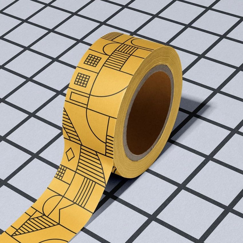 Packing tape mockup featuring a roll of yellow tape with black geometric patterns on a grid-patterned surface.
