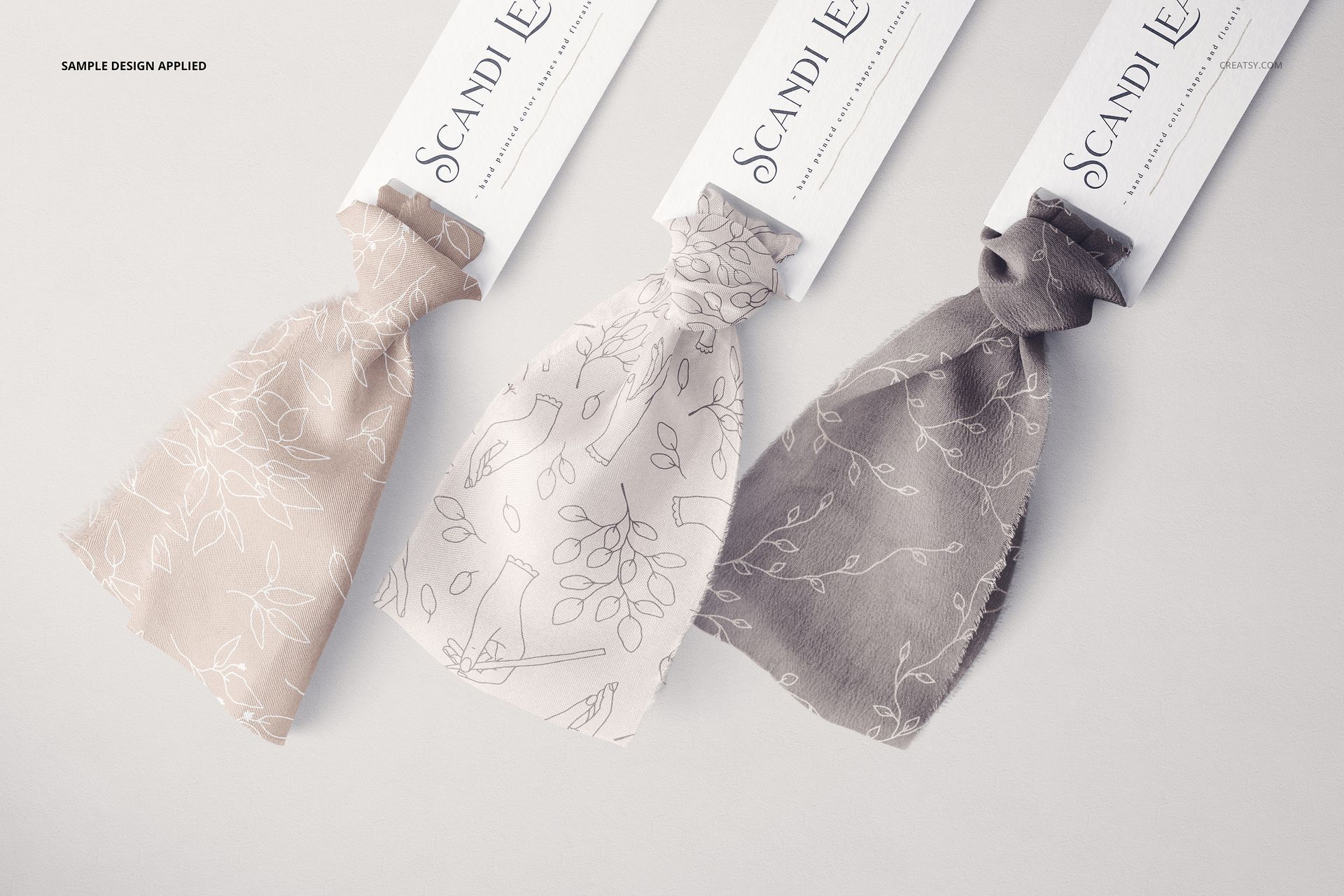 Three silk ribbons in beige and gray tones with floral line designs, shown with labels in a realistic mockup scene.
