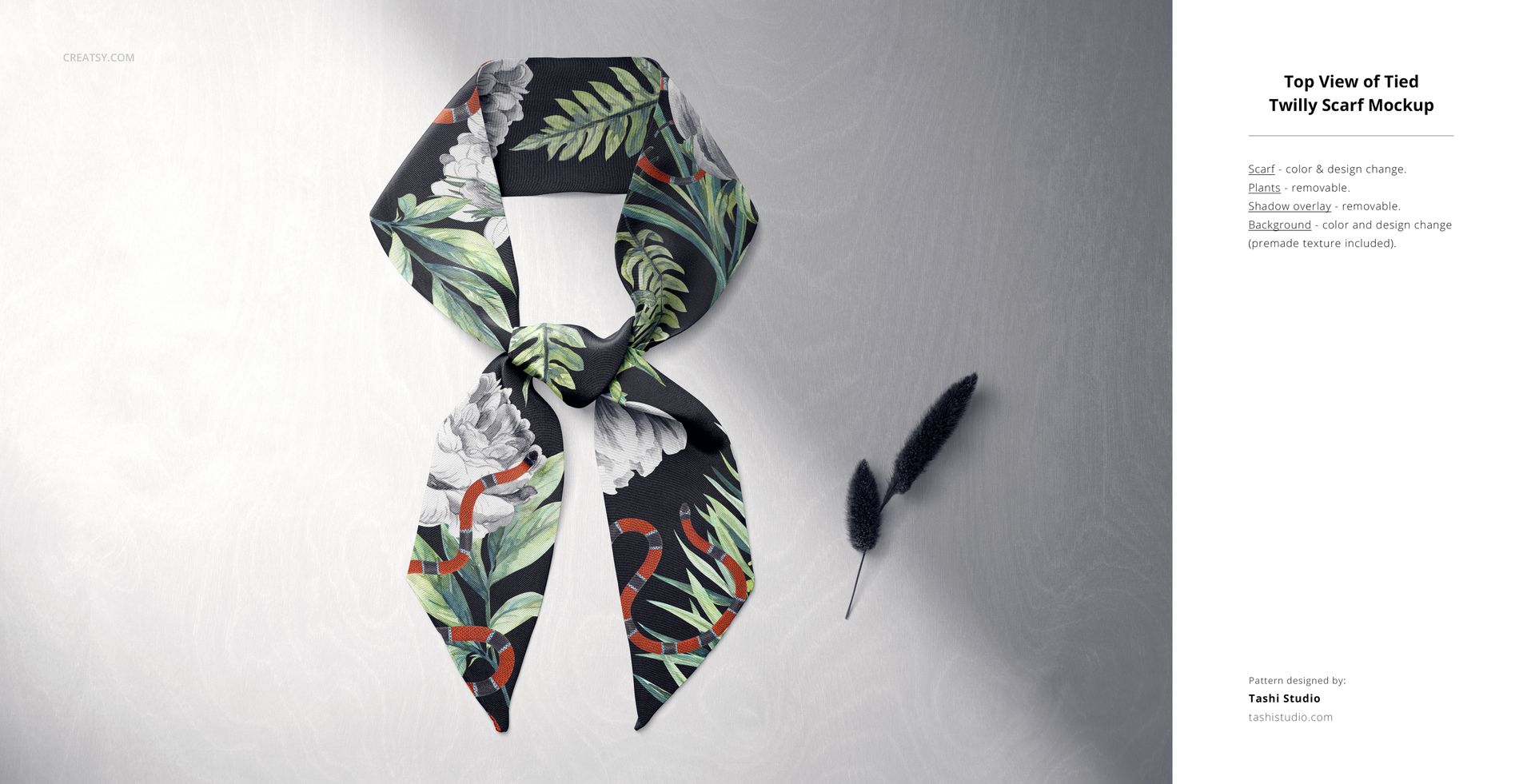 Tied twilly scarf mockup featuring green leaves and white flowers on a dark fabric, shown from above on a textured base.