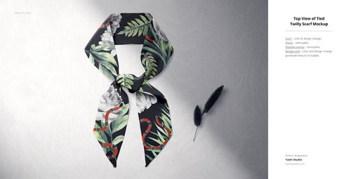 Tied twilly scarf mockup featuring green leaves and white flowers on a dark fabric, shown from above on a textured base.