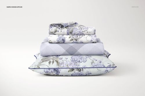 Front view of a PSD mockup featuring a braided pillow, blanket, and pillowcases in pastel blue floral and argyle designs.