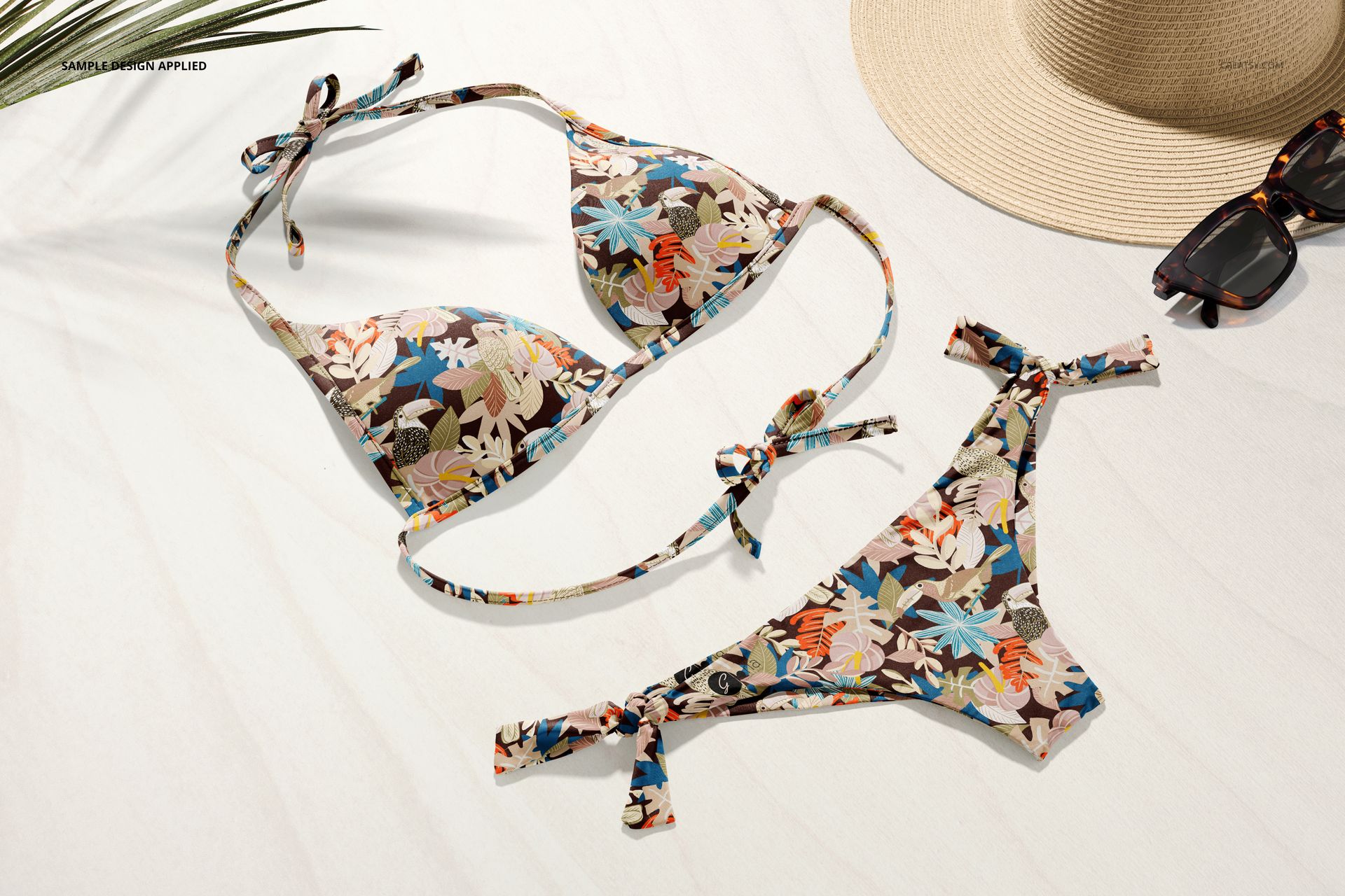 Bikini mockup set featuring a colorful floral design, shown from above with summer accessories on a white background.