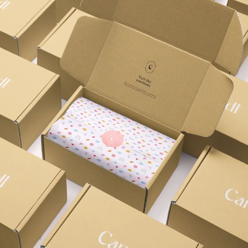 Mailing box mockup featuring an open kraft box with patterned tissue paper inside, surrounded by closed boxes on a white surface.