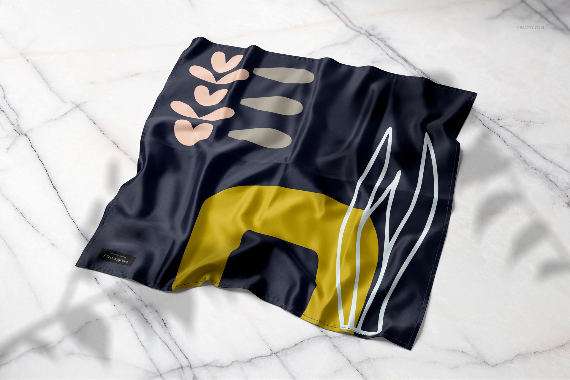 Narrow hem silk scarf mockup displayed on a marble surface, showing bold geometric and organic patterns, top perspective.