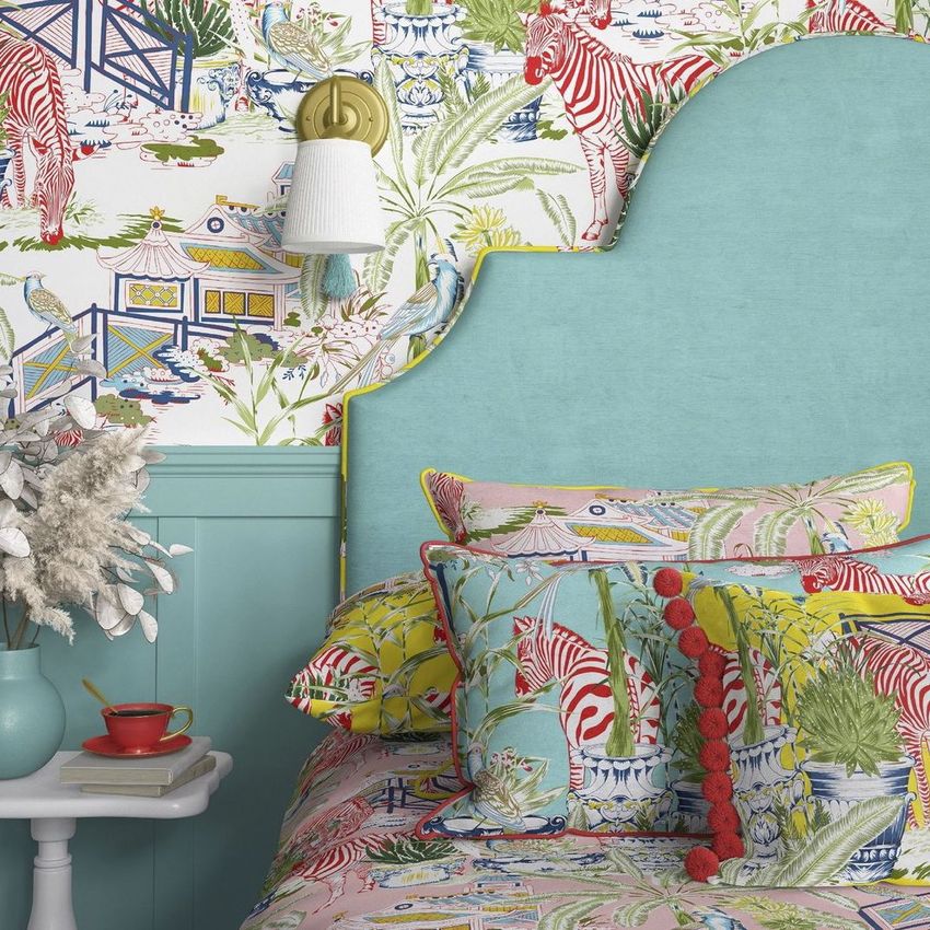 Bedroom mockup showing a turquoise headboard, patterned pillows, and wallpaper with tropical plants and red zebras.