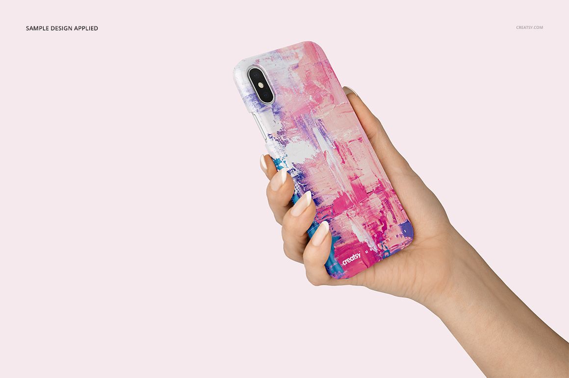 Front view of an iPhone X plastic case mockup with vibrant pink and purple artwork, held by a hand against a soft background.