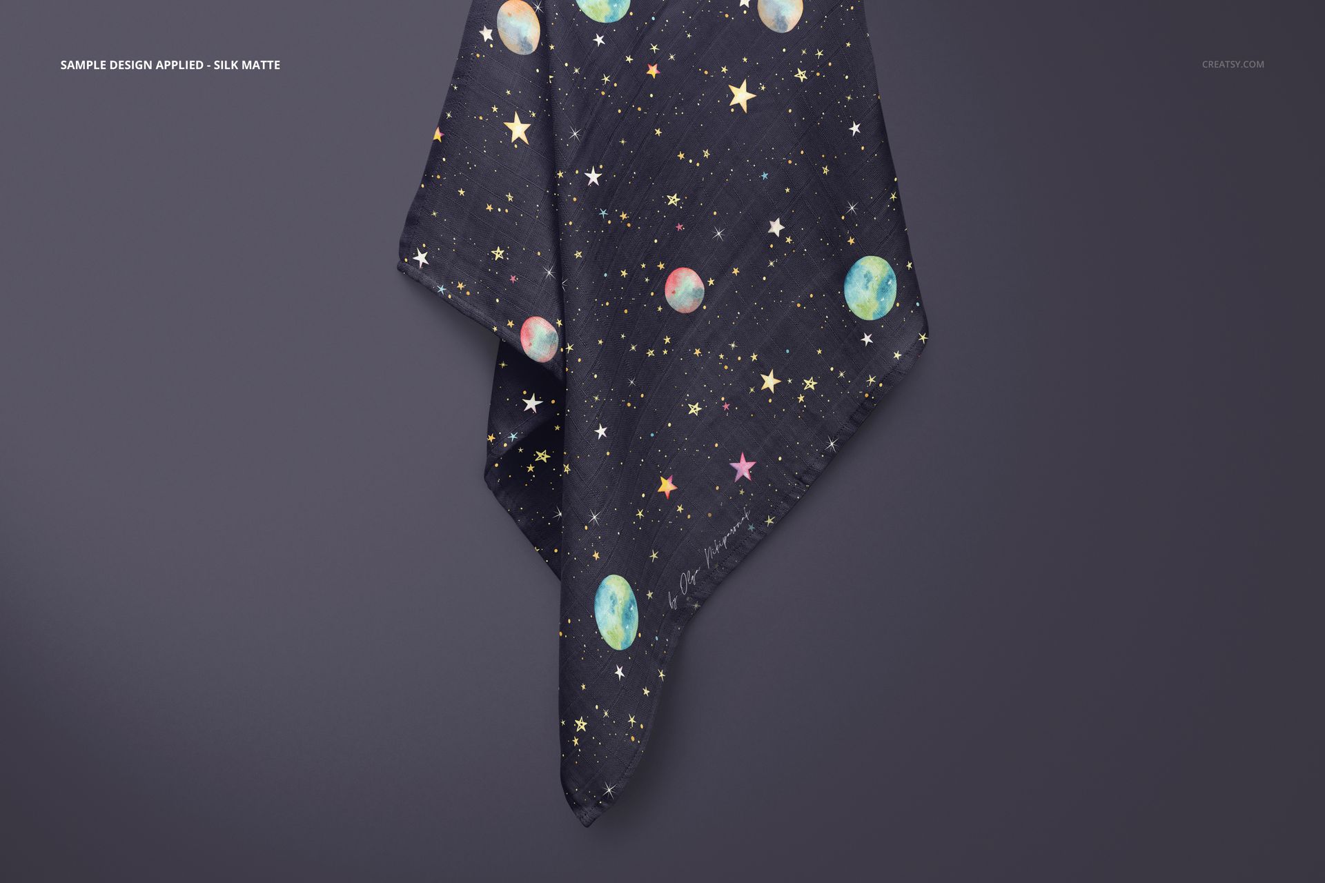 Muslin swaddle blanket mockup featuring a dark fabric with moon and star pattern, hanging against a plain wall.