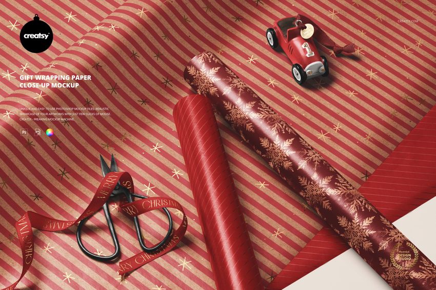 Christmas-themed gift wrapping paper mockup featuring red and gold rolls, scissors, ribbon, and a toy car in a close-up view.