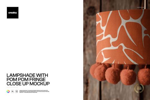 Orange and white patterned lampshade mockup shown from the side, highlighting pom pom fringe detail and rustic background.
